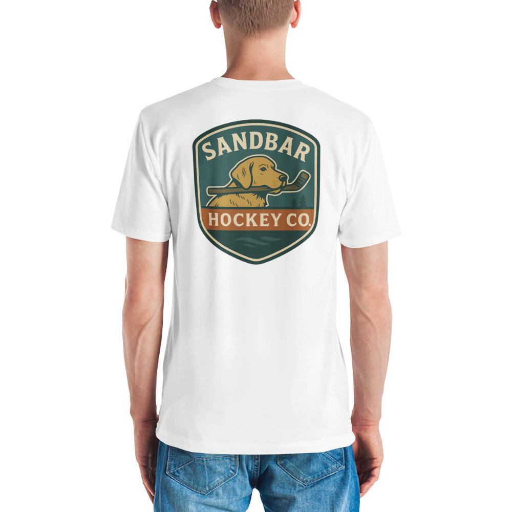 White hockey t-shirt shown from the back with a large Sandbar Hockey Co. dog shield graphic centered on the upper back, featuring a golden dog holding a hockey stick in its mouth.