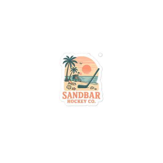 Small Sandbar Hockey Co. sticker with palm trees, beach sunset, lifeguard stand, seashells, ocean water, and a hockey stick in the sand.