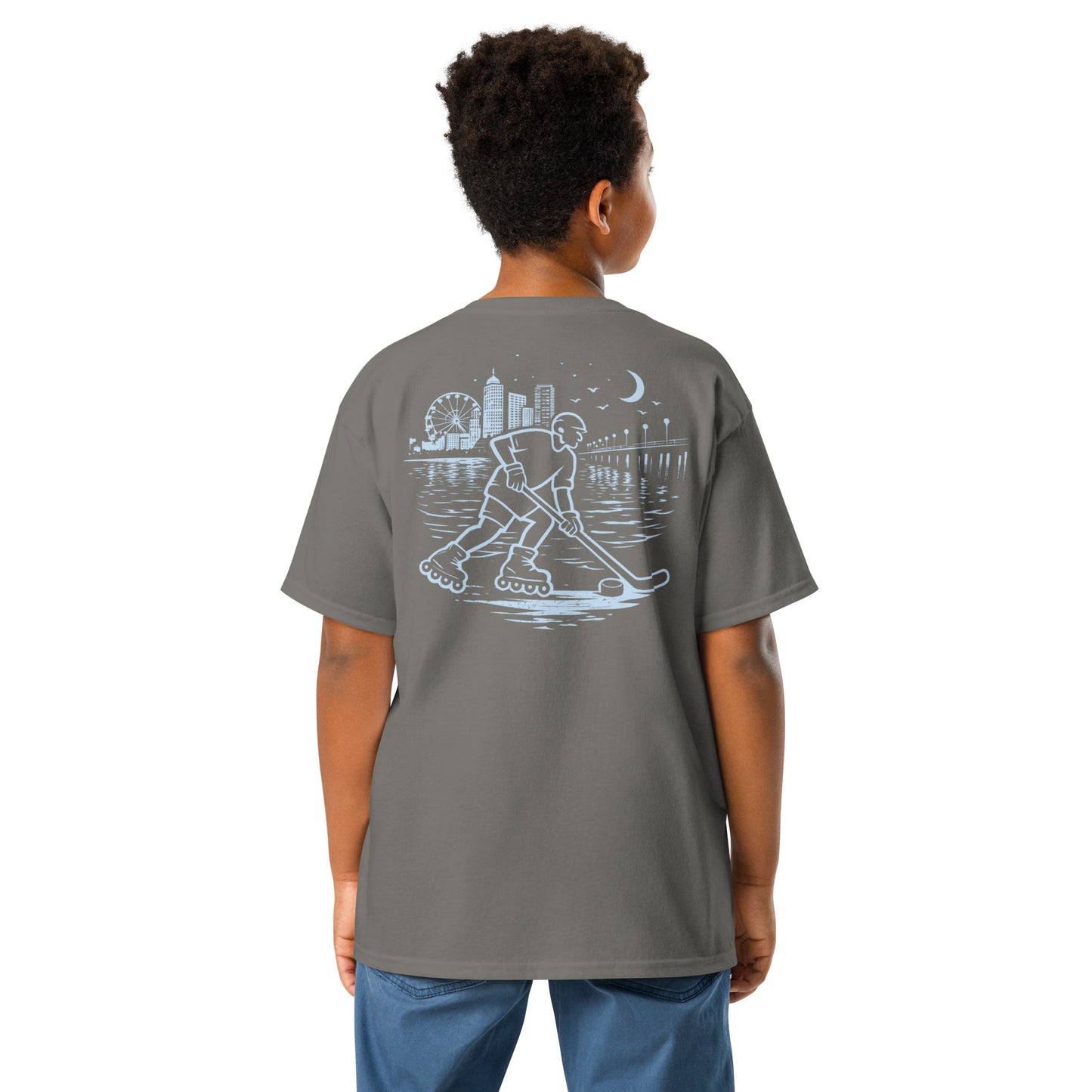 Youth charcoal roller hockey t-shirt back view worn by a boy with baby blue waterfront roller hockey graphic featuring a skater, city skyline, ferris wheel, pier, moon, and water reflections.