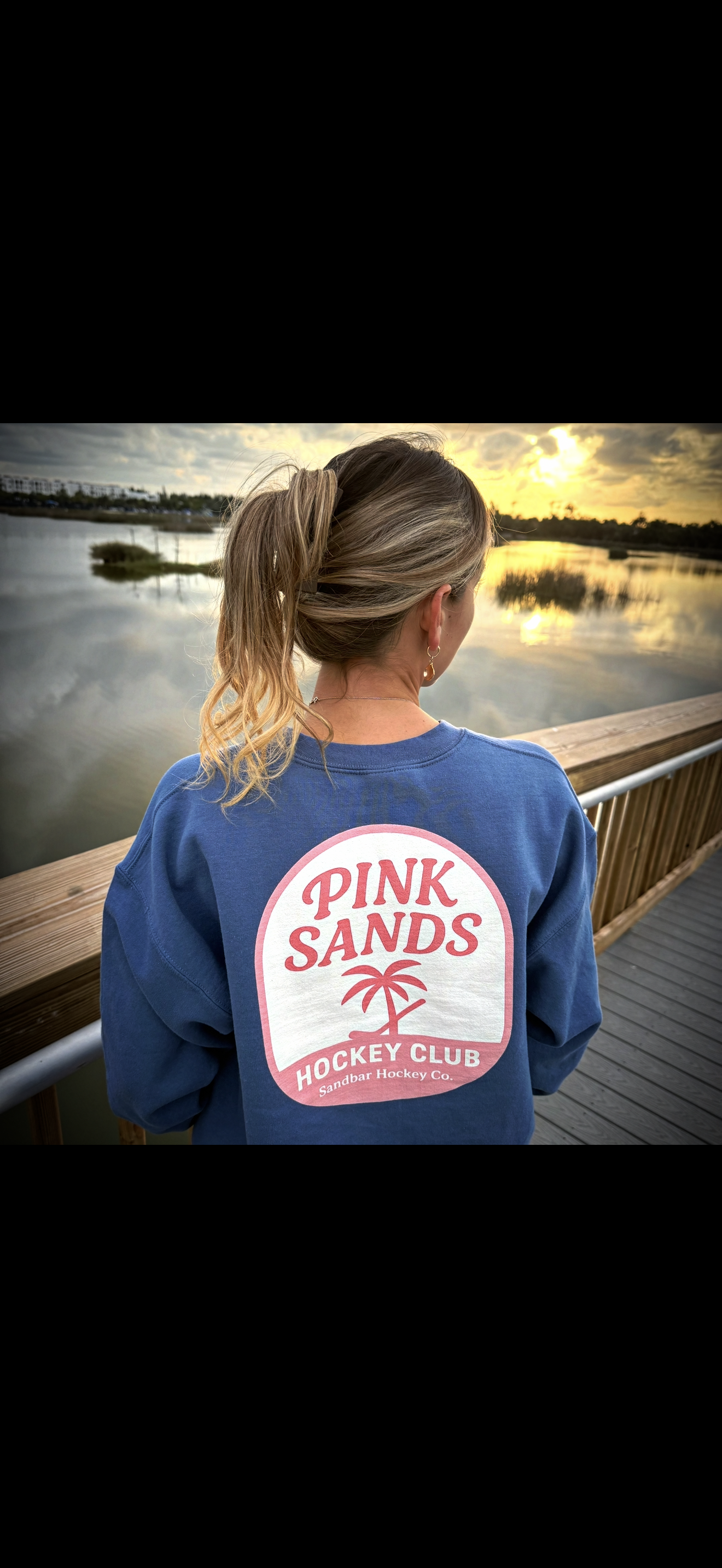 Blue hockey crewneck lifestyle image showing back side with Pink Sands Hockey Club graphic