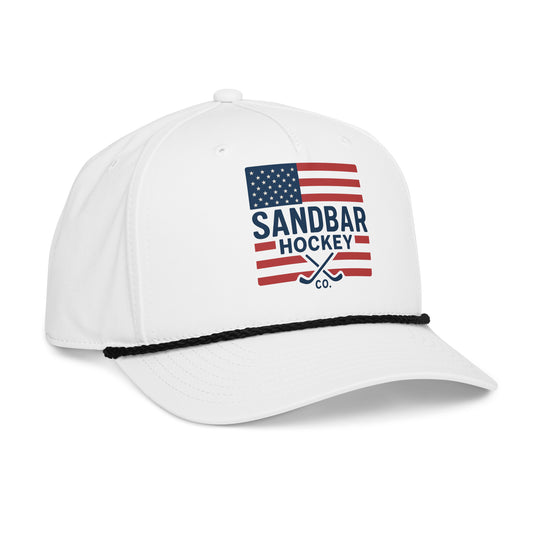 White USA hockey rope hat left front angle view with American flag Sandbar Hockey Co. graphic, black rope detail, and curved brim.