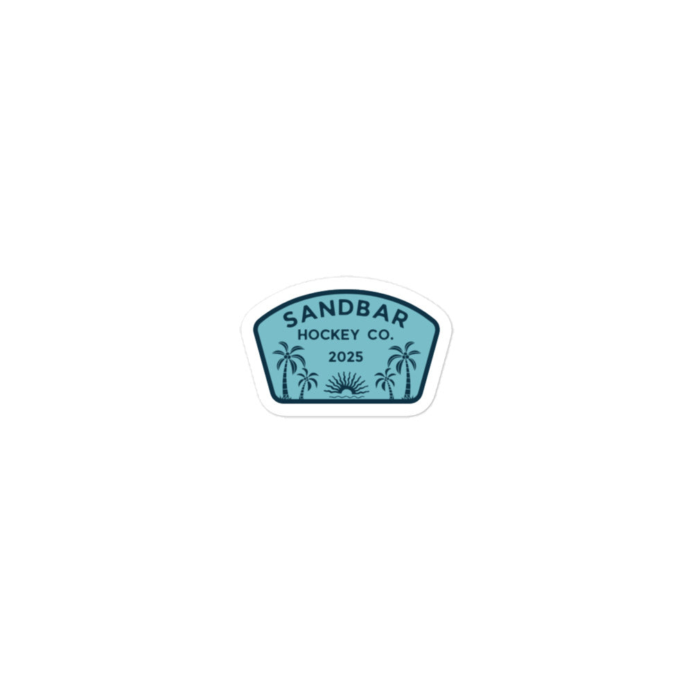 Small Sandbar Hockey Co. 2025 sticker with a teal badge design, palm trees, sunrise, and bold logo text.