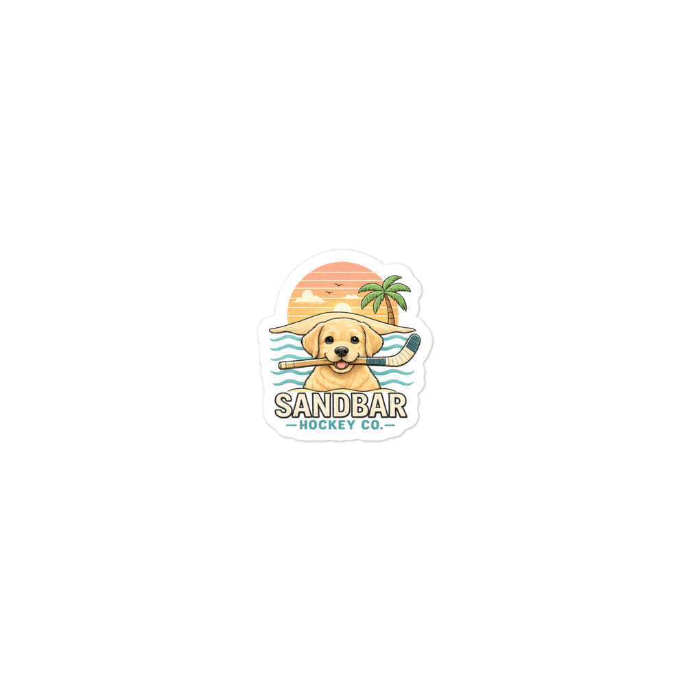 Small Sandbar Hockey puppy sticker featuring a golden lab holding a hockey stick with a beach sunset, palm tree, ocean waves, and Sandbar Hockey Co. lettering.