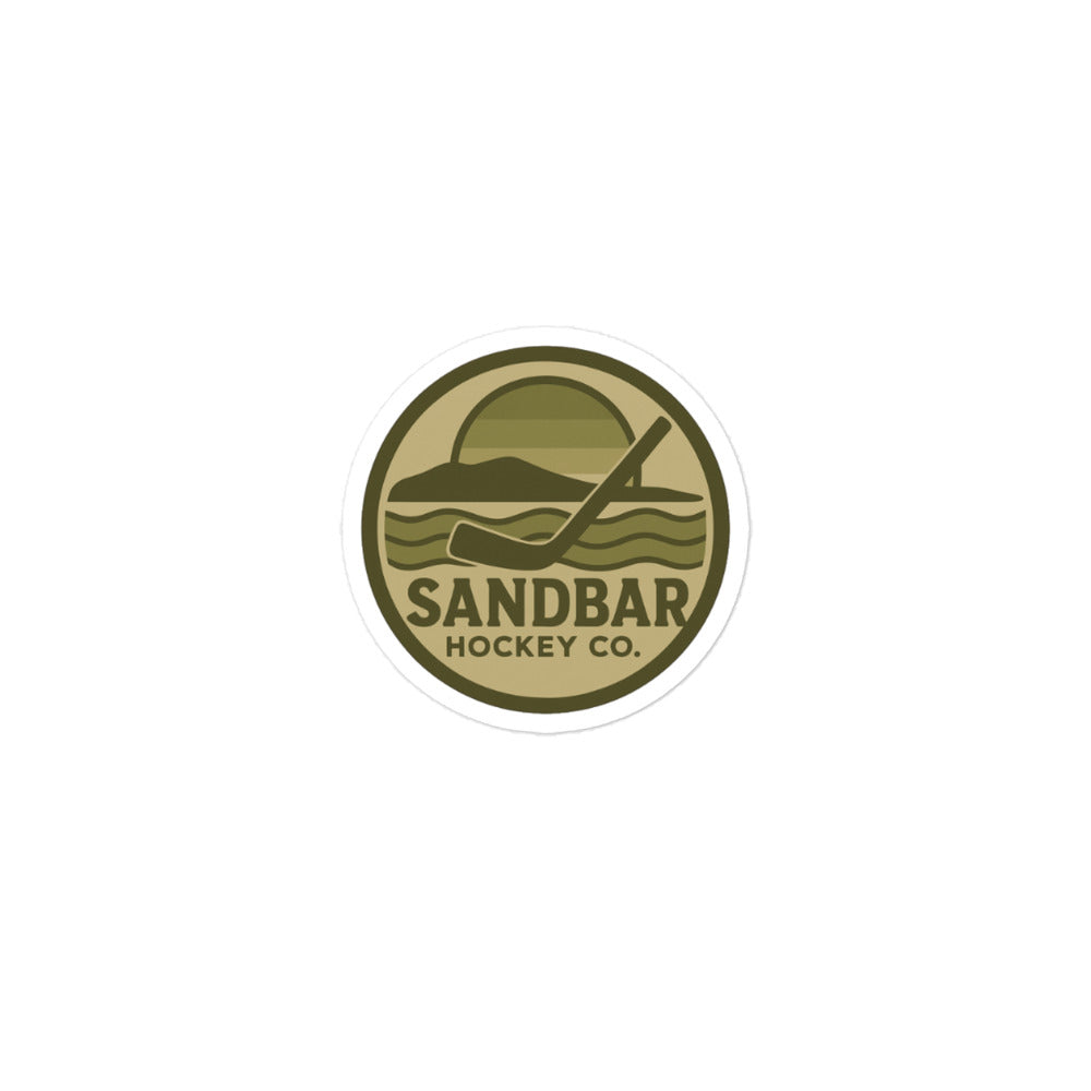 Small Sandbar Hockey Co. camo circular logo sticker featuring a coastal hockey scene with a sunset, shoreline, waves, and hockey stick.