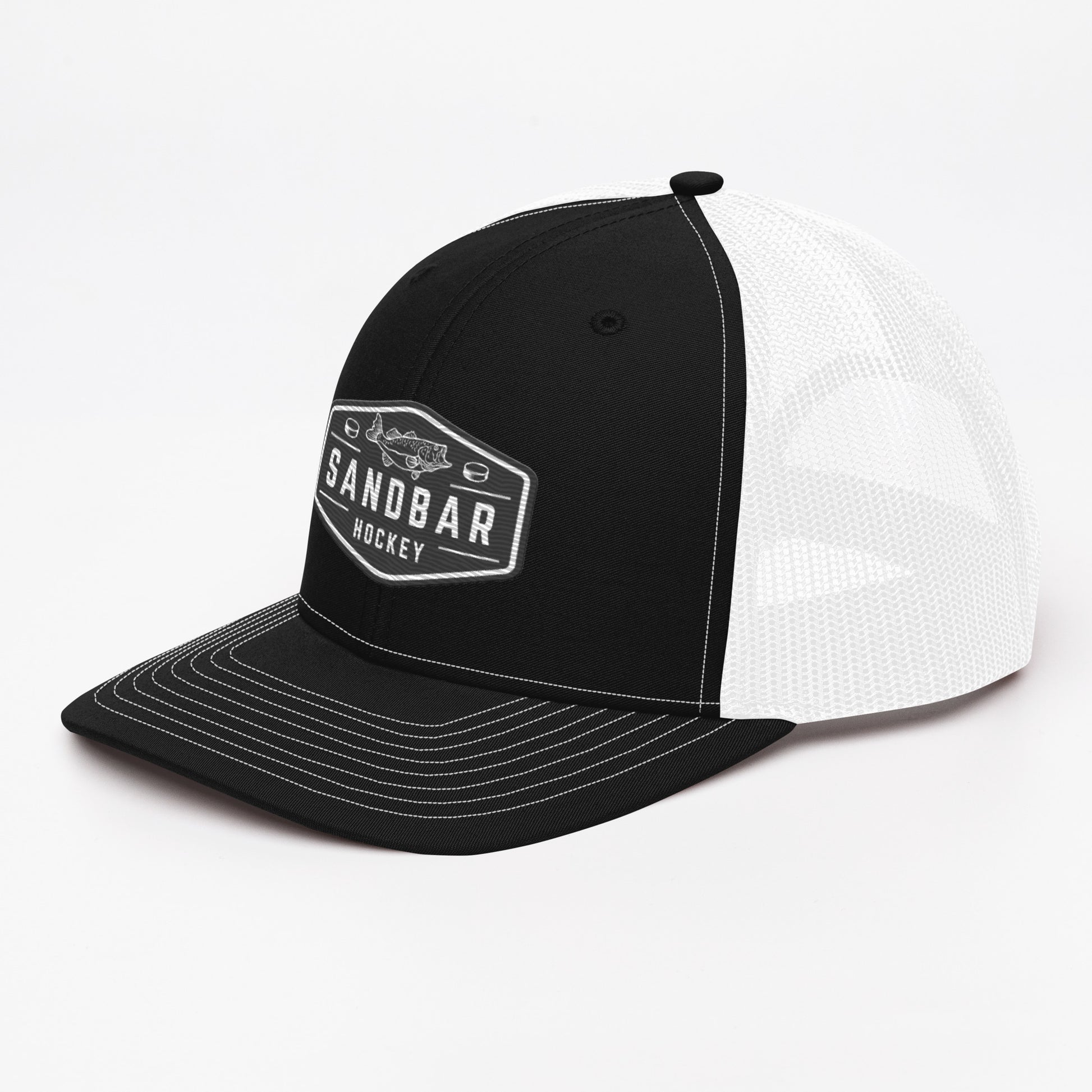 Black and white Sandbar Hockey snapback hat left side angle view with black front panel, white mesh back, and black rectangular badge logo featuring a fish