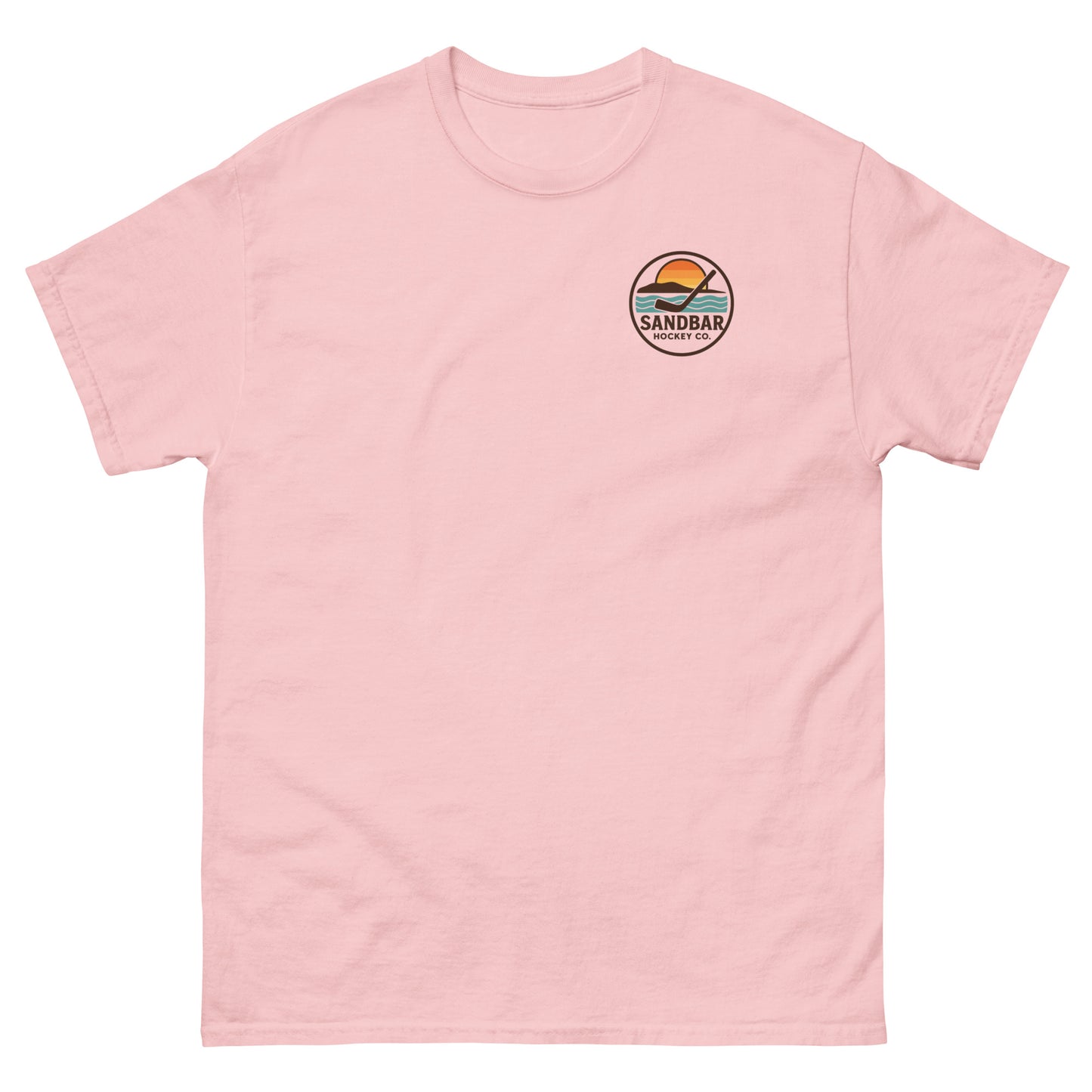 Pink T-shirt with a small left chest logo showing a sunset, ocean waves, and a hockey stick with the text “Sandbar Hockey Co.”