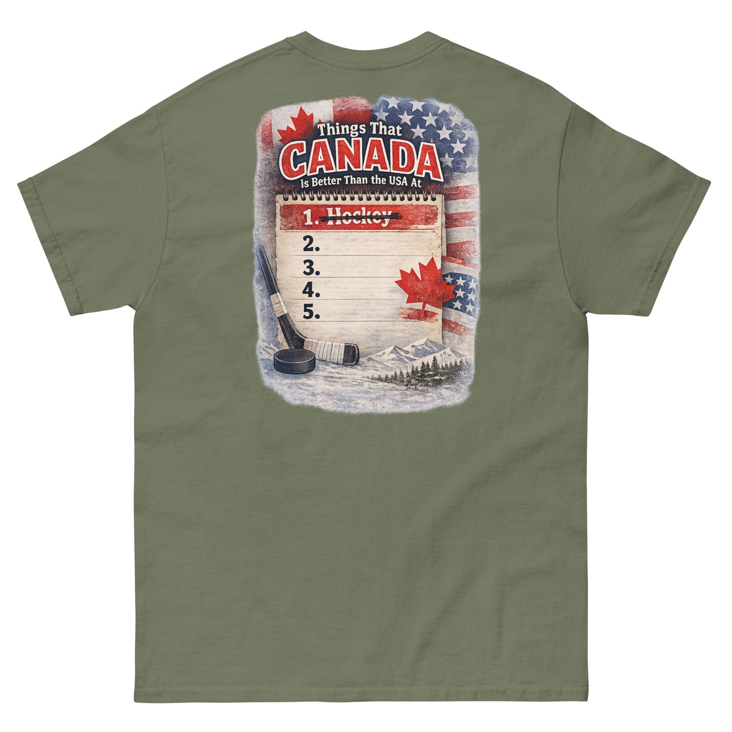 Military green hockey t-shirt with large back graphic that reads “Things That Canada Is Better Than the USA At” with “Hockey” crossed out at number one, plus American and Canadian flag elements, a hockey stick, puck, and mountain background.