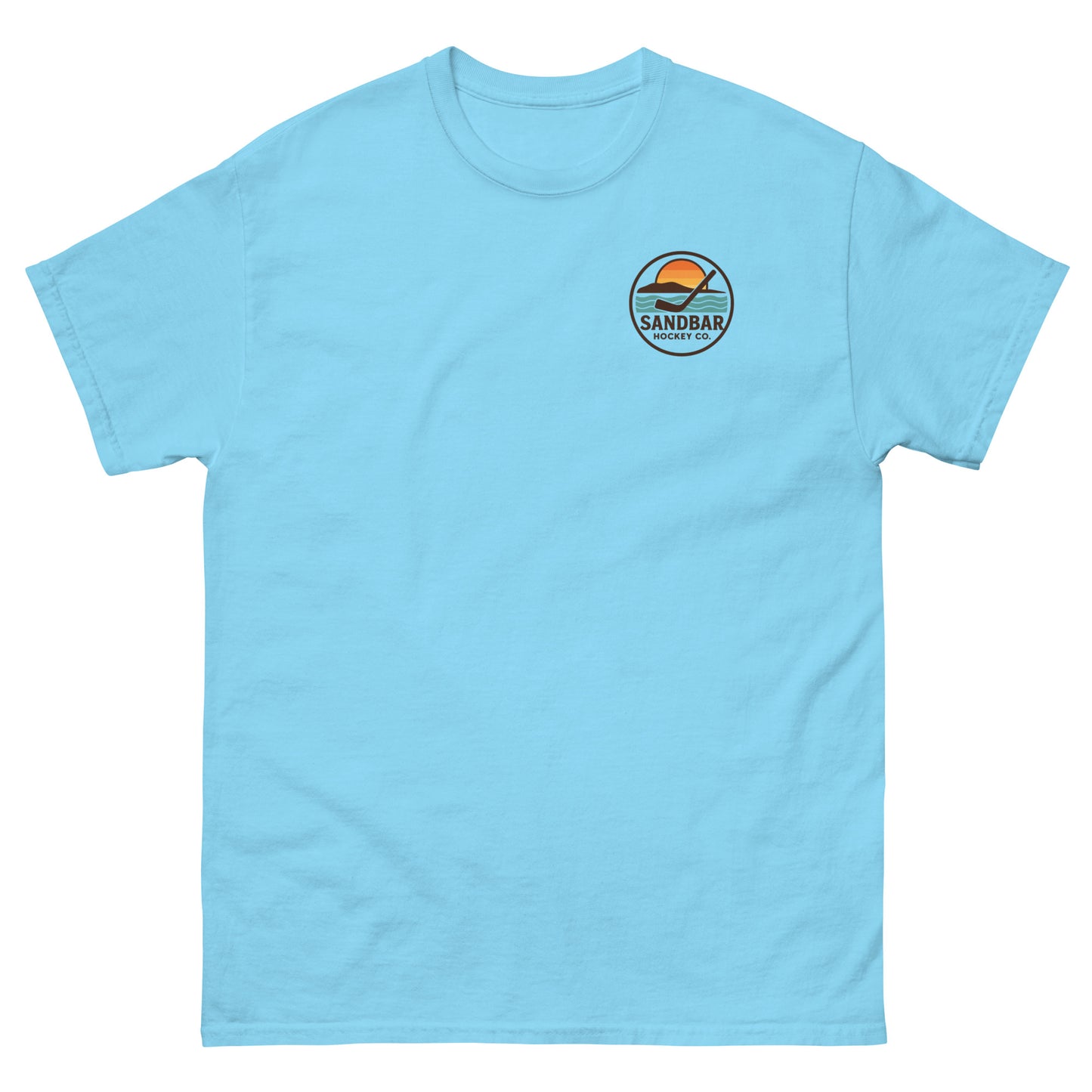 Sky blue T-shirt with a small left chest logo showing a sunset, ocean waves, and a hockey stick with the text “Sandbar Hockey Co.”