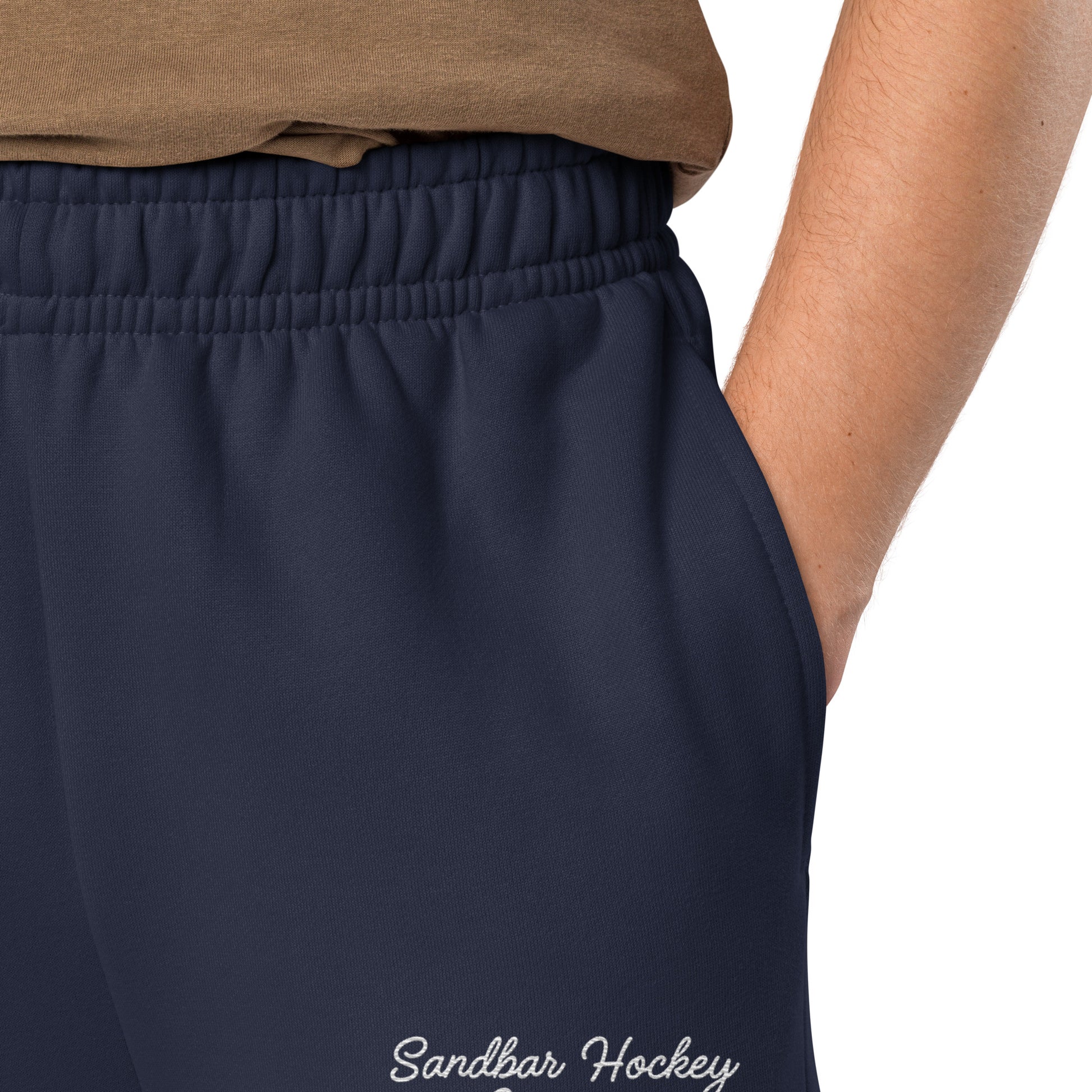 Navy hockey sweatpants close-up of left leg with Sandbar Hockey Company cursive logo