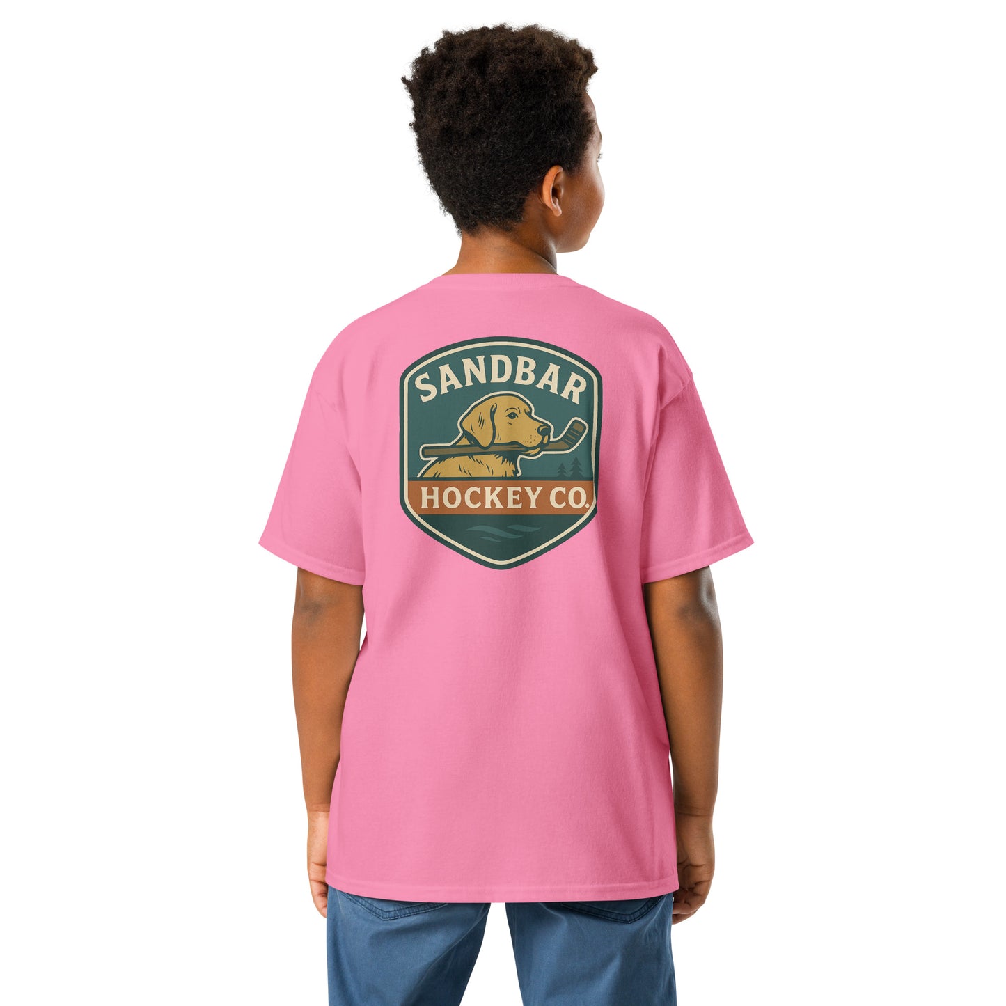 Youth pink Sandbar Hockey Dog Badge T-Shirt back view on model with large badge graphic of a dog holding a hockey stick in its mouth