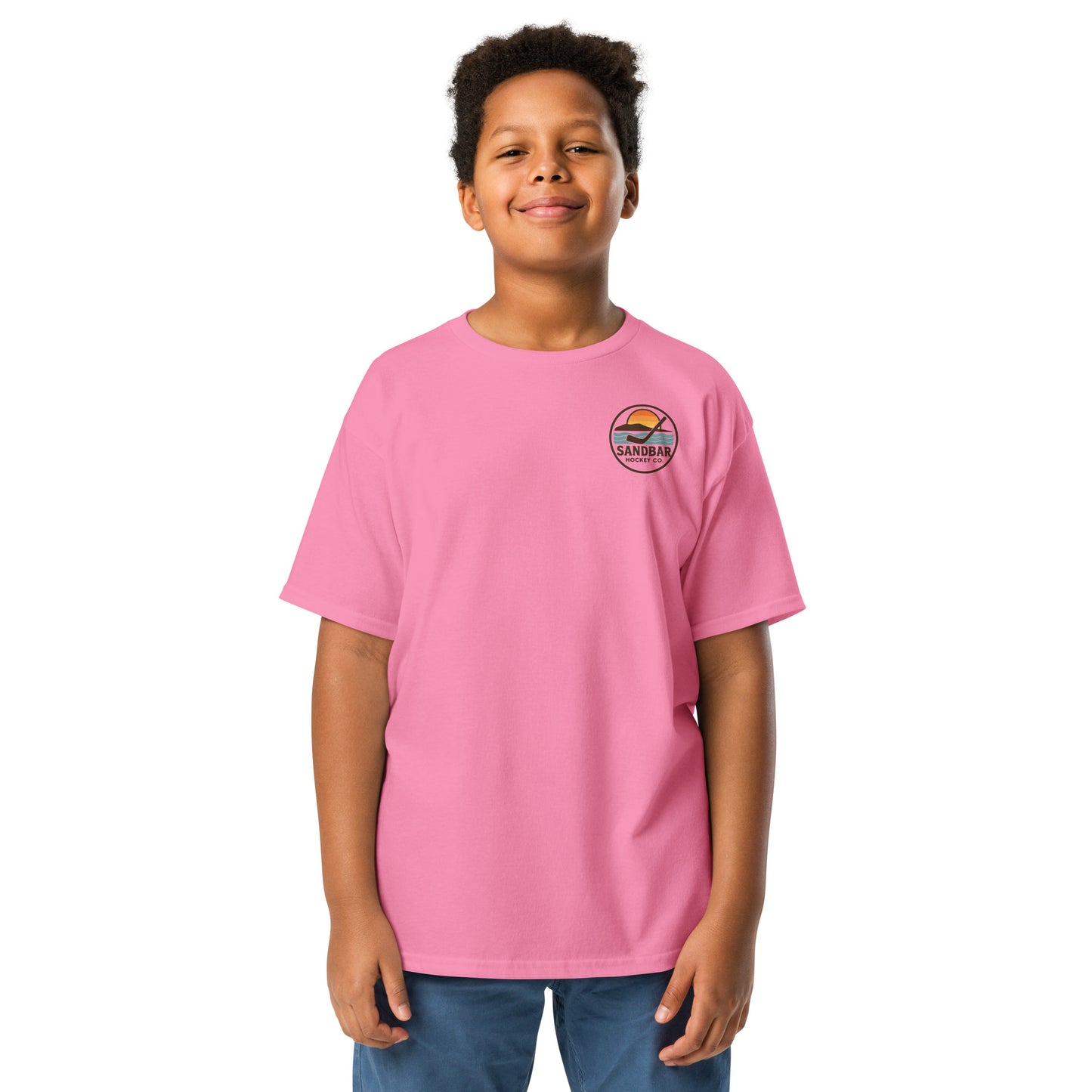 Youth pink Sandbar Hockey Dog Badge T-Shirt front view on model with small circular Sandbar Hockey Co. chest logo