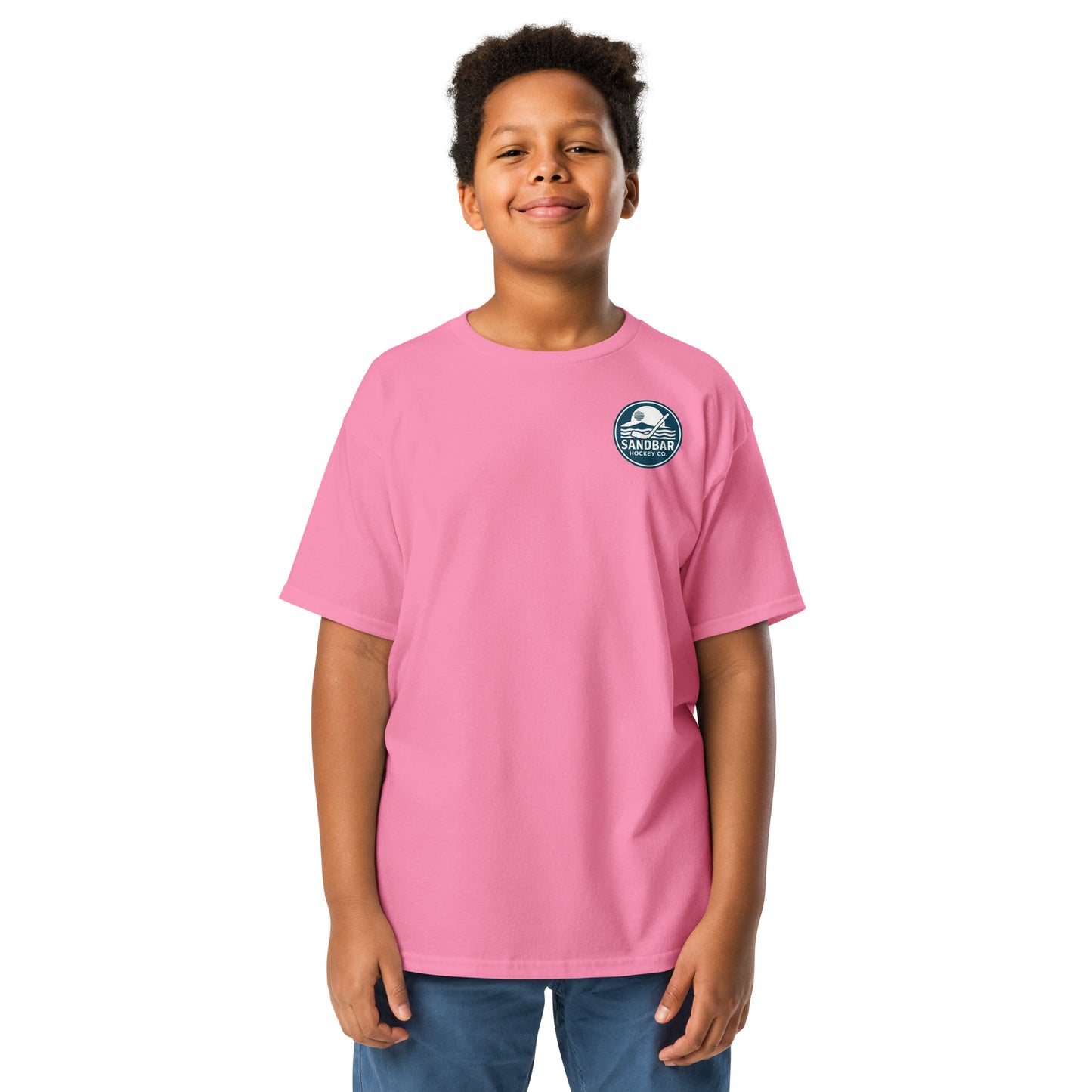 Pink Youth Fort Myers Sandbar Hockey T-shirt front view with small circular Sandbar Hockey Co. chest logo showing sunset, island, water, and a hockey stick