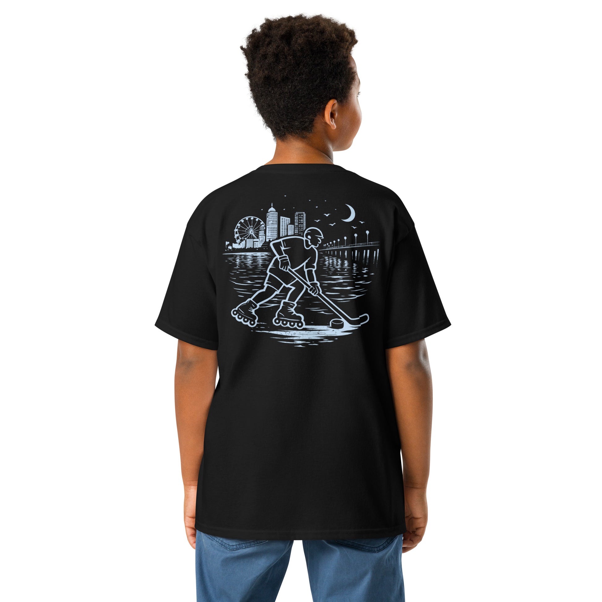 Youth midnight roller hockey t-shirt back view worn by a boy with baby blue waterfront roller hockey graphic featuring a skater, city skyline, ferris wheel, pier, moon, and water reflections.
