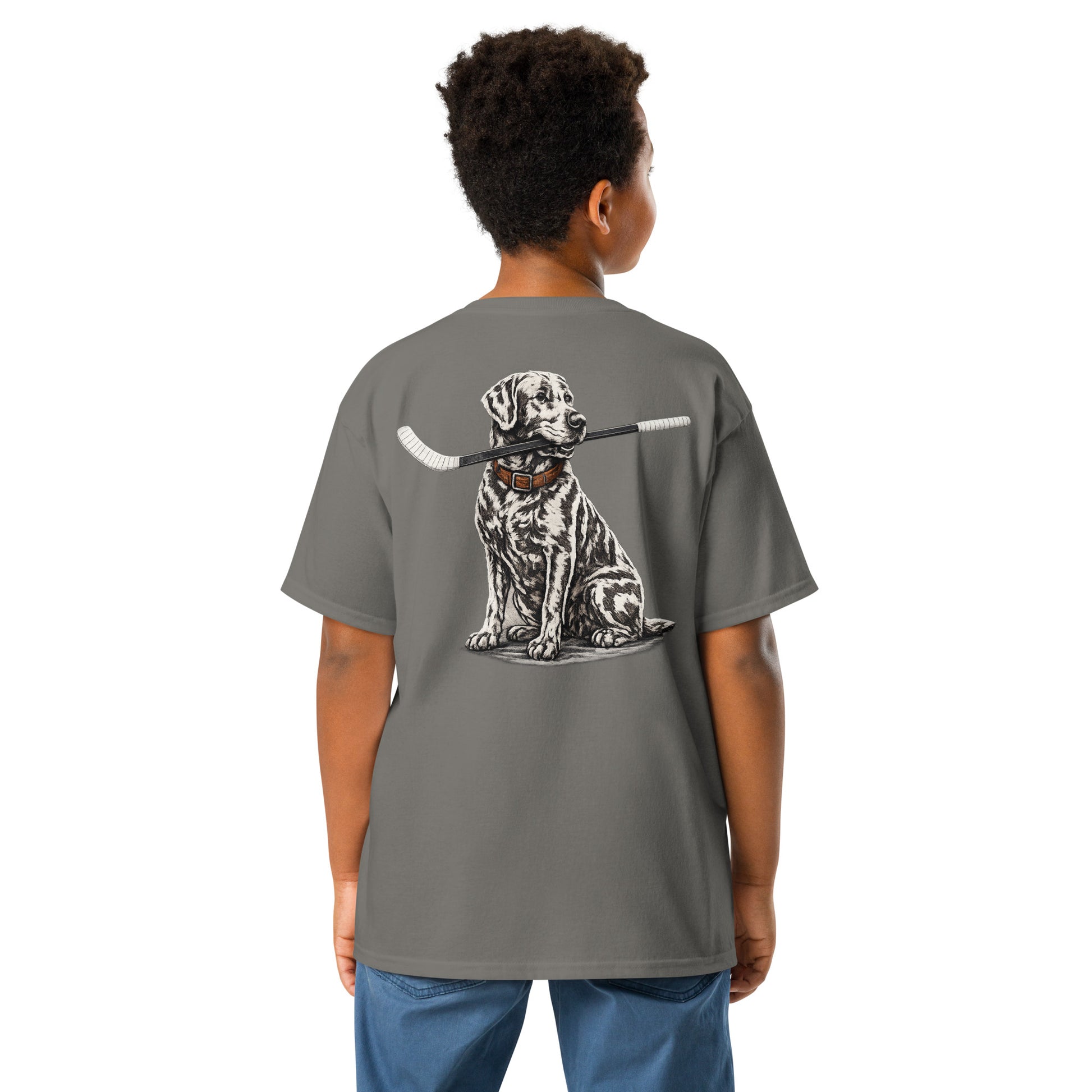 Charcoal youth hockey t-shirt shown from the back on a child model, featuring a large back graphic of a realistic dog holding a hockey stick in its mouth.