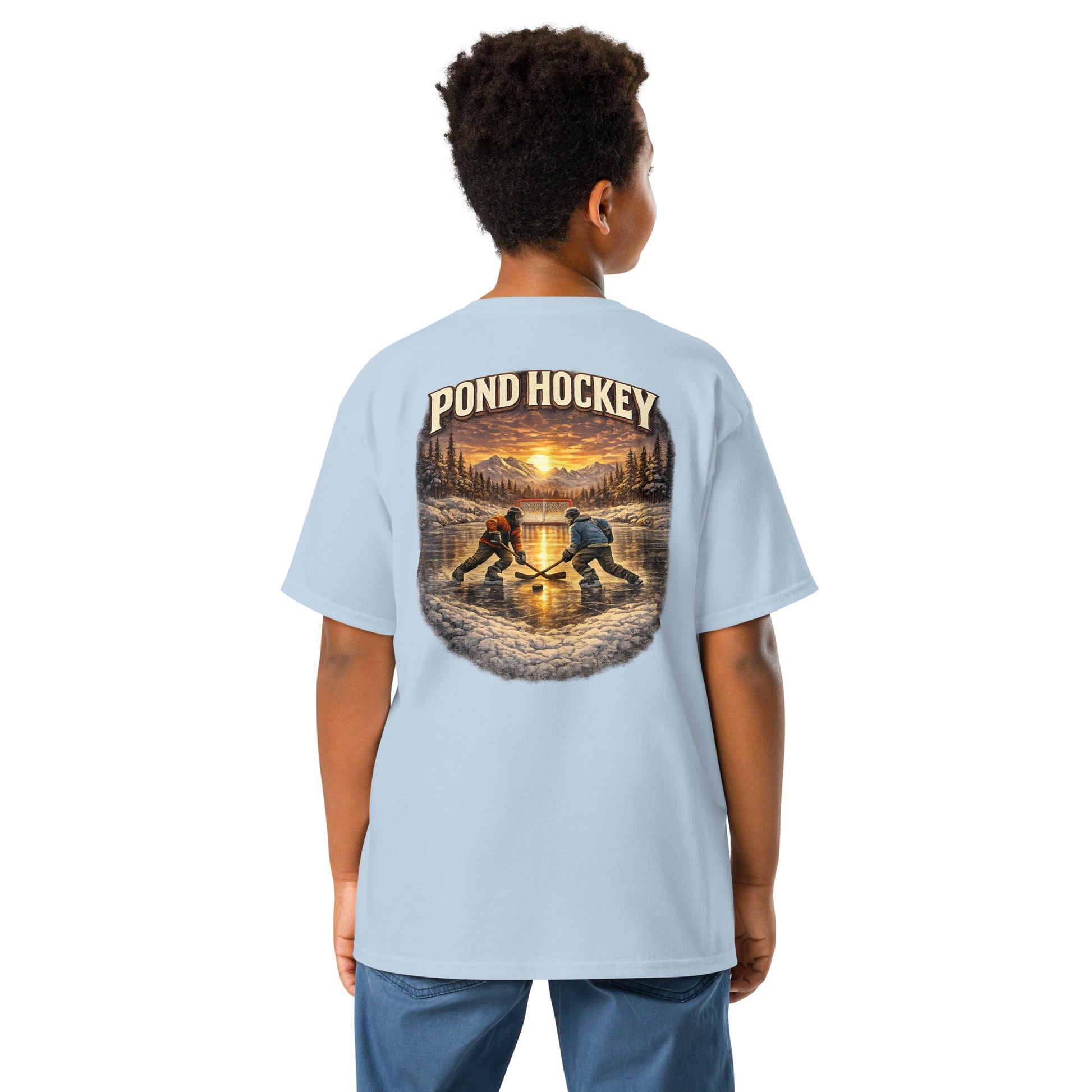 Light blue youth T-shirt with a large back graphic showing two hockey players on a frozen pond at sunset, with mountains, pine trees, a goal net, and “POND HOCKEY” in bold lettering above.
