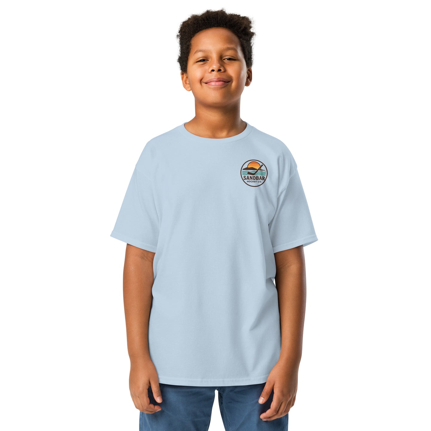 Youth light blue Sandbar Hockey Dog Badge T-Shirt front view on model with small circular Sandbar Hockey Co. chest logo