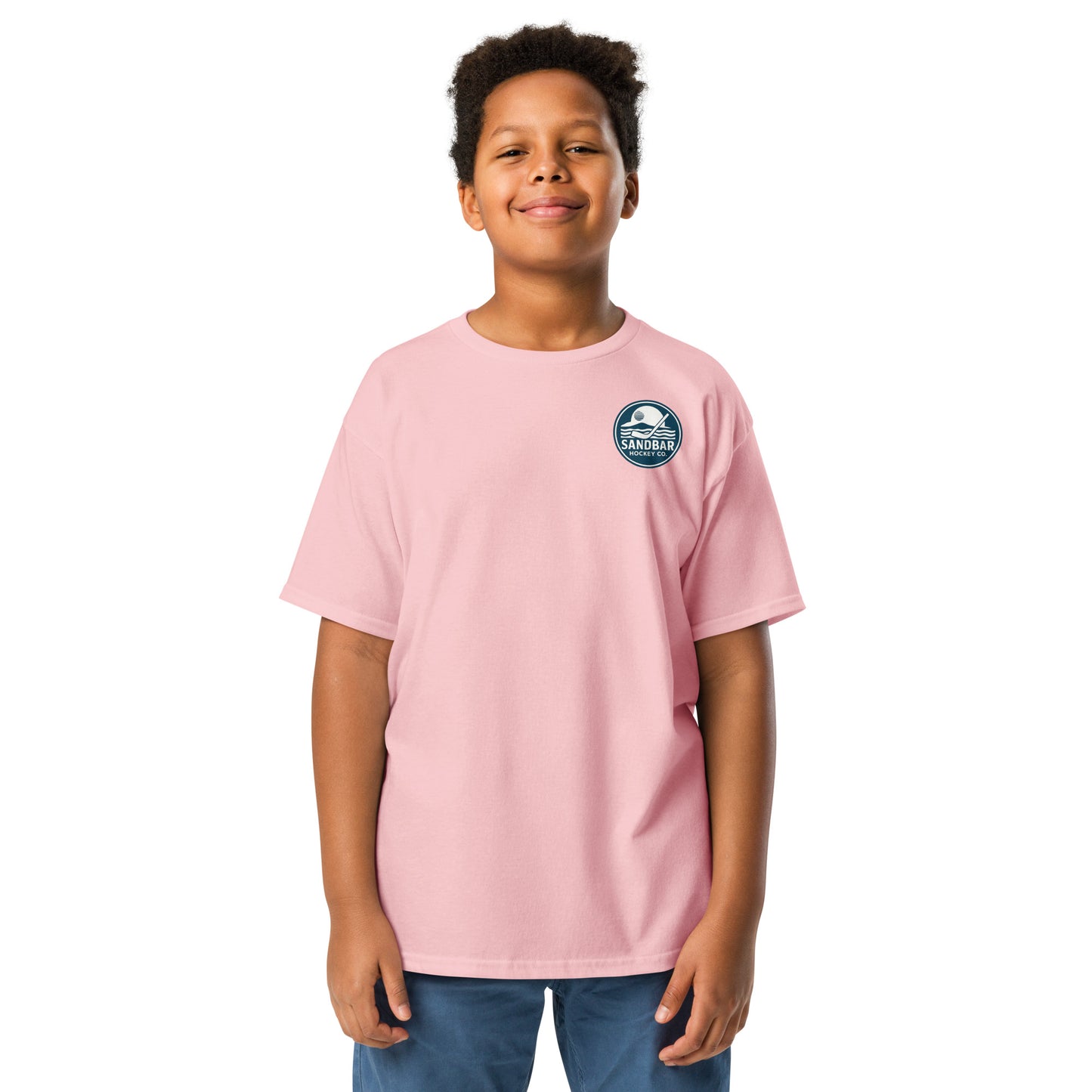 Light pink Youth Fort Myers Sandbar Hockey T-shirt front view with small circular Sandbar Hockey Co. chest logo showing sunset, island, water, and a hockey stick
