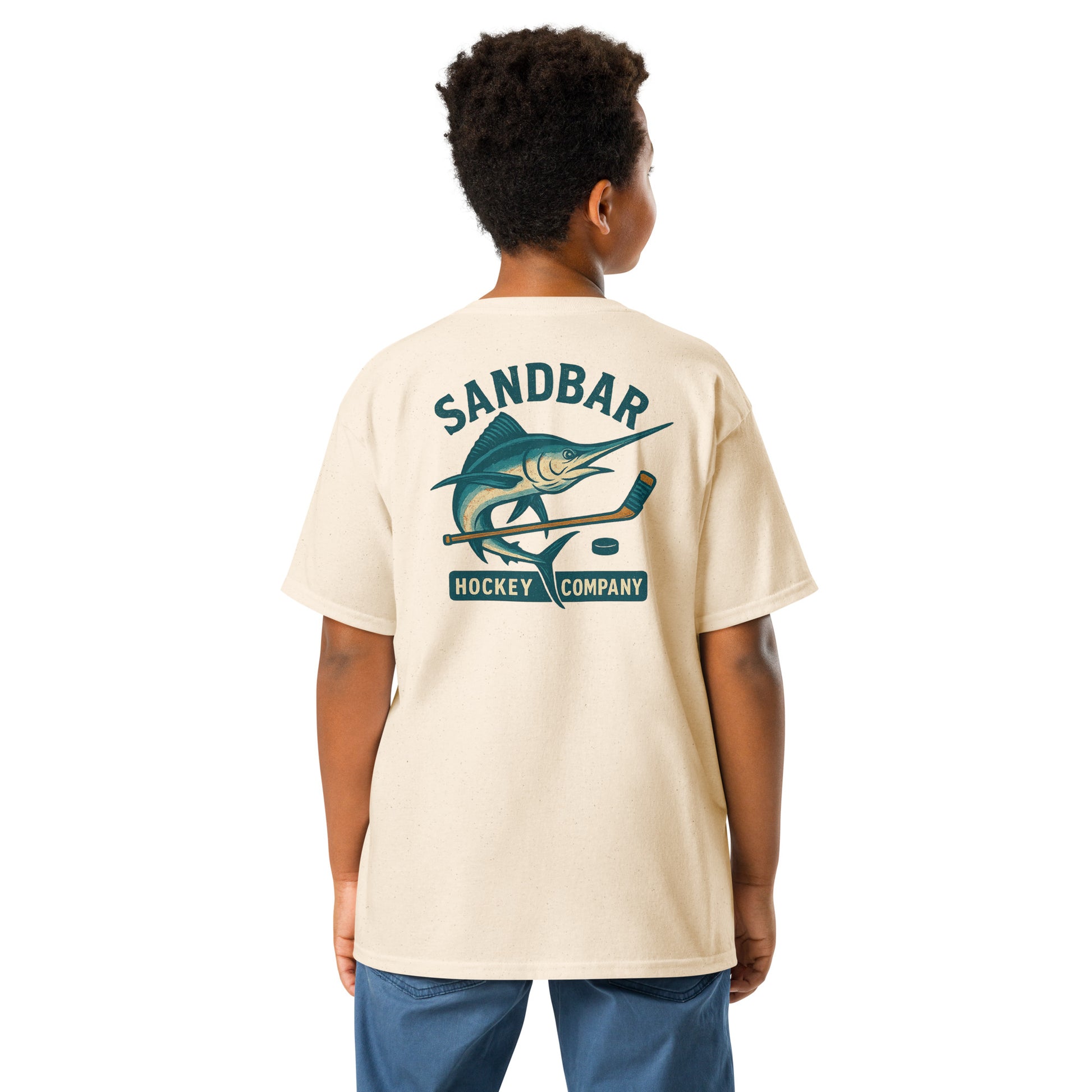 Natural youth hockey t-shirt back side on model with marlin and hockey stick graphic and Sandbar Hockey Company text
