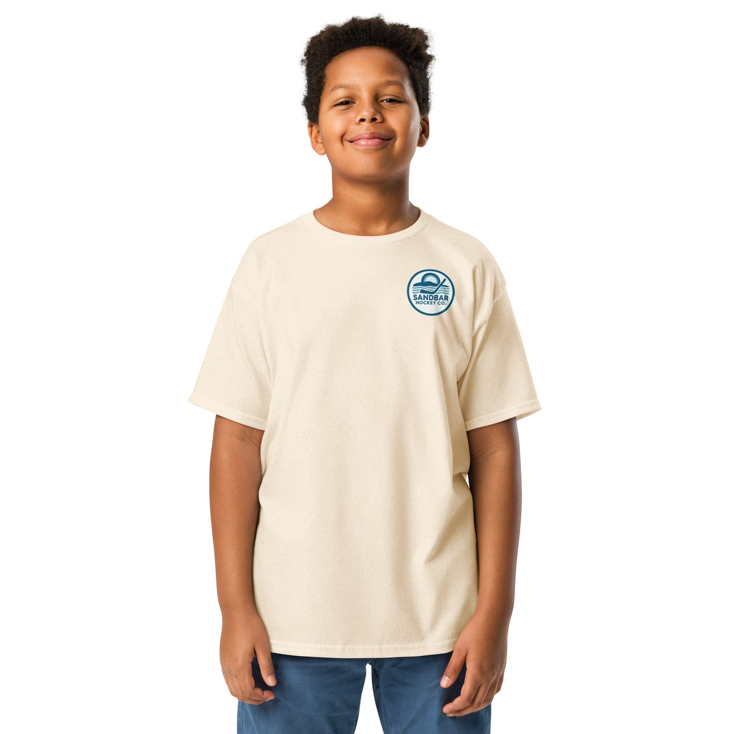 Natural youth hockey t-shirt front side on model with small circular Sandbar Hockey Co. sunset, water, and hockey stick chest logo