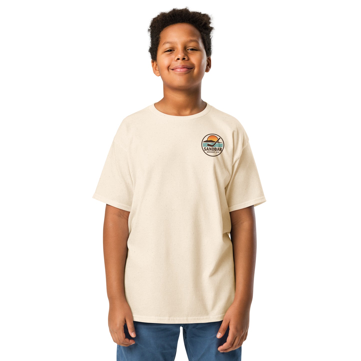 Youth natural Sandbar Hockey Dog Badge T-Shirt front view on model with small circular Sandbar Hockey Co. chest logo