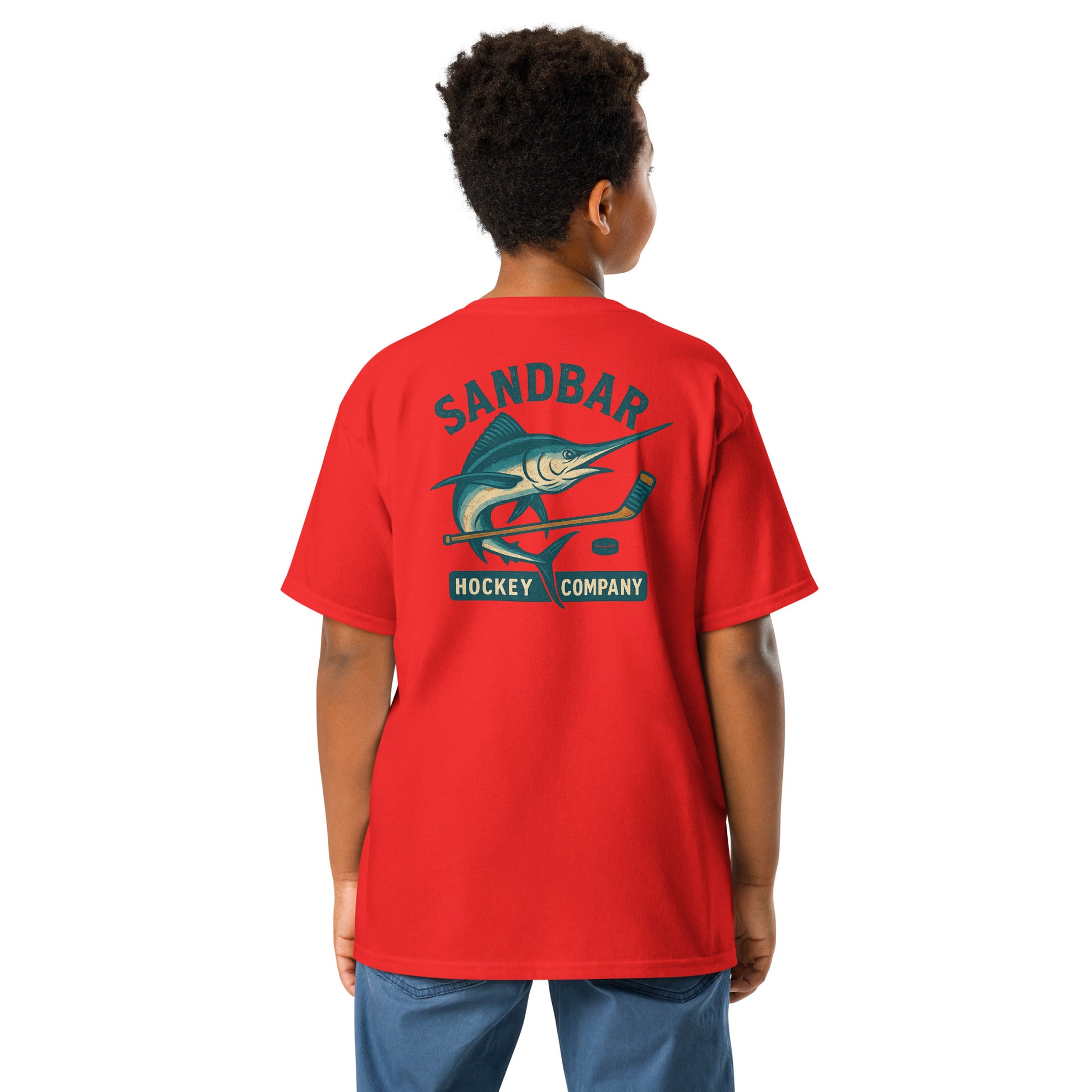 Red youth hockey t-shirt back side on model with marlin and hockey stick graphic and Sandbar Hockey Company text