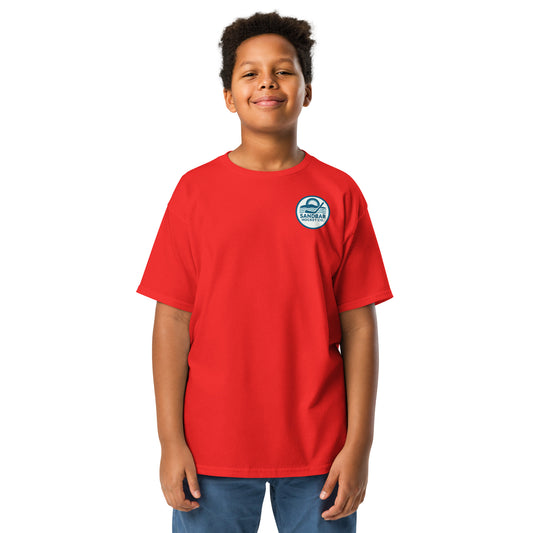 Red youth hockey t-shirt front side on model with small circular Sandbar Hockey Co. sunset, water, and hockey stick chest logo