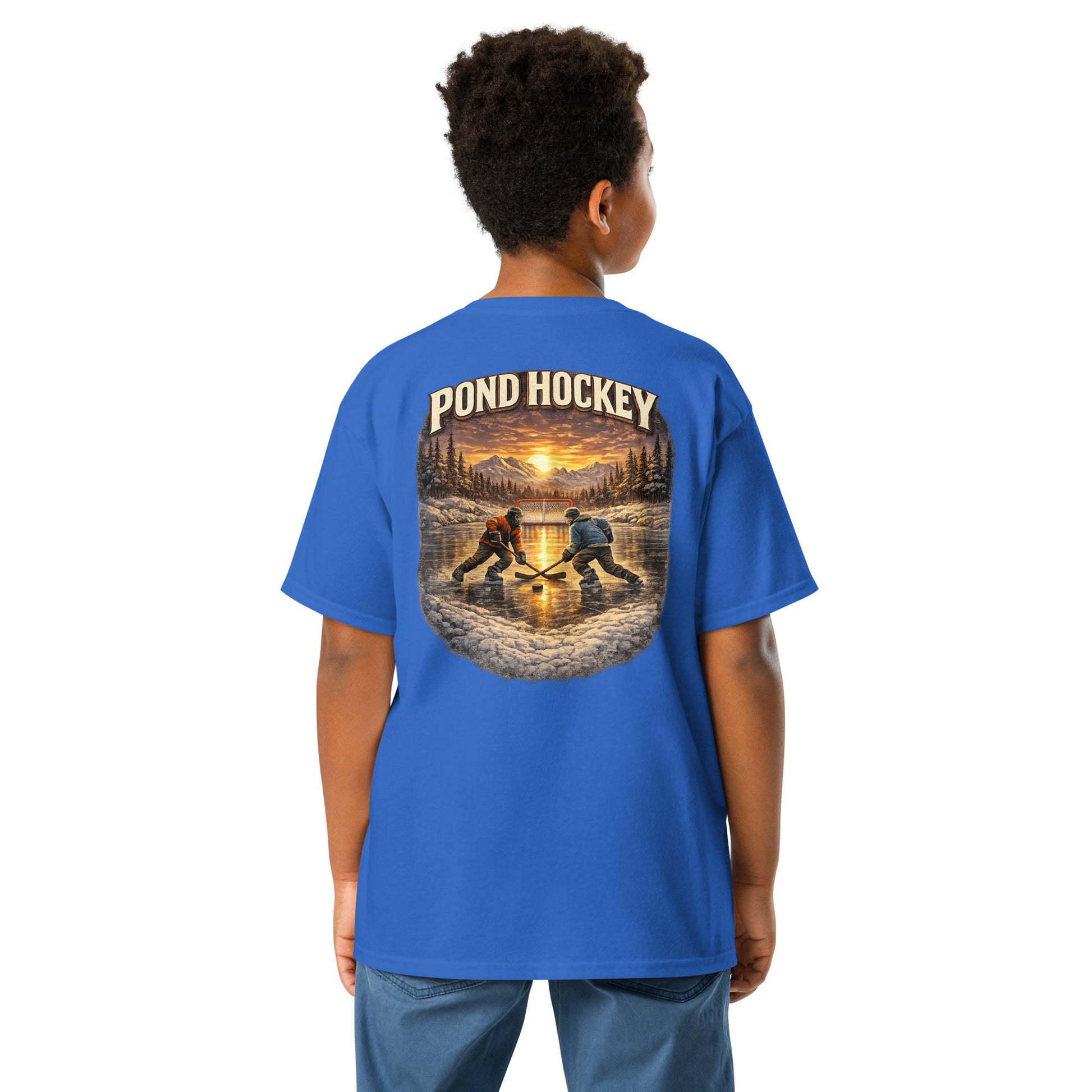 Royal blue youth T-shirt with a large back graphic showing two hockey players on a frozen pond at sunset, with mountains, pine trees, a goal net, and “POND HOCKEY” in bold lettering above.