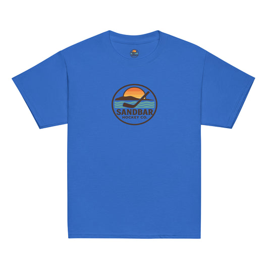 Blue youth hockey t-shirt front side with circular Sandbar Hockey Co. sunset, wave, and hockey stick logo