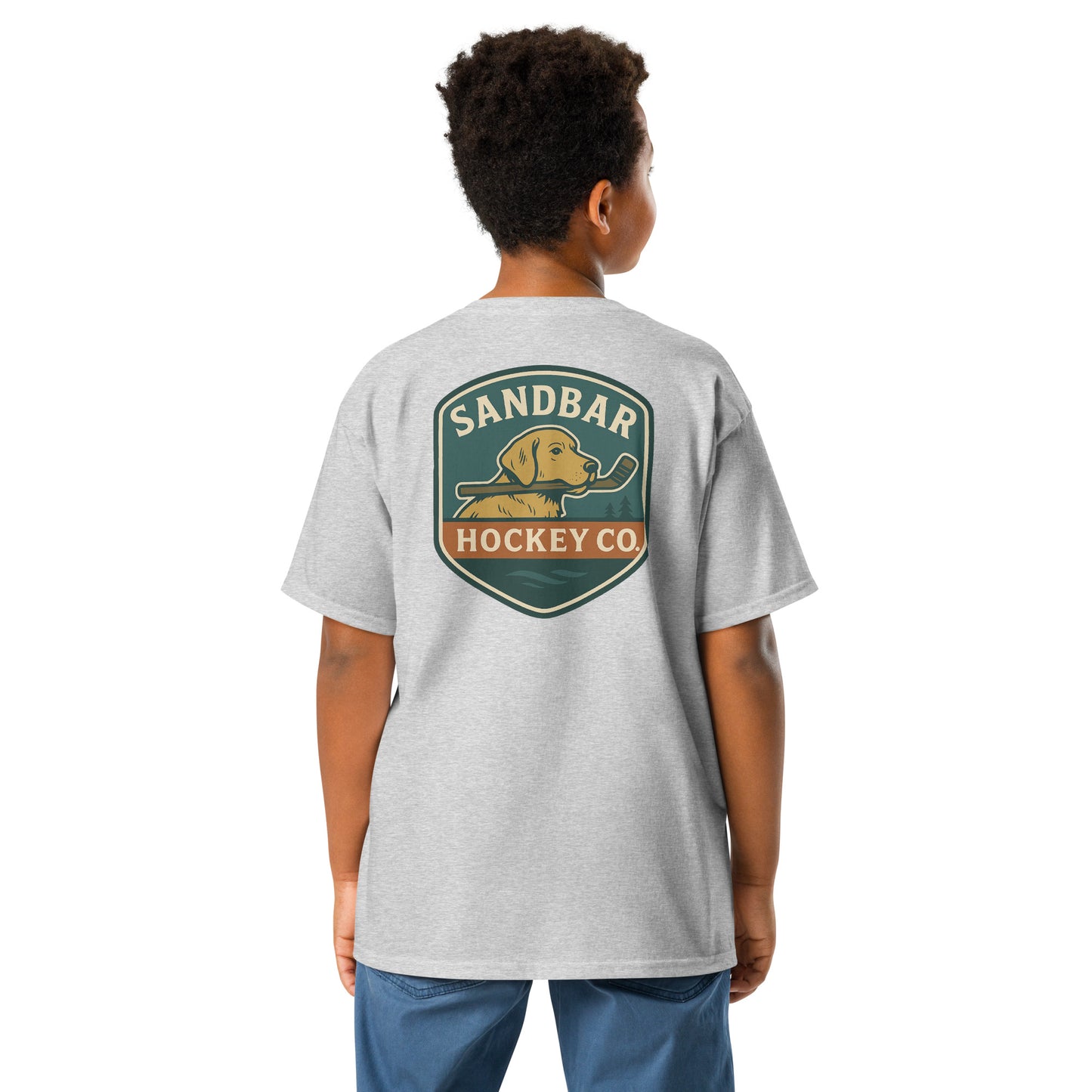 Youth grey Sandbar Hockey Dog Badge T-Shirt back view on model with large badge graphic of a dog holding a hockey stick in its mouth