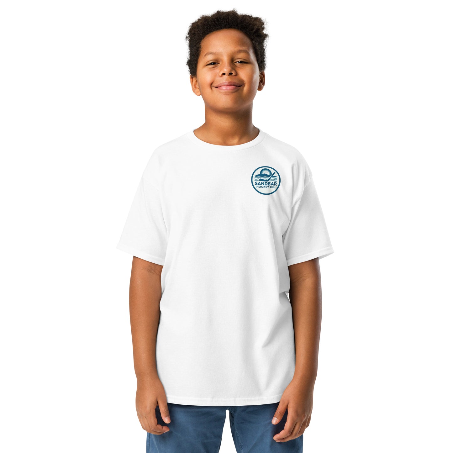 White youth hockey t-shirt front side on model with small circular Sandbar Hockey Co. sunset, water, and hockey stick chest logo