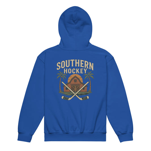 Royal blue youth hockey hoodie back side with Southern Hockey barn graphic, crossed hockey sticks, palm trees, and sunset design
